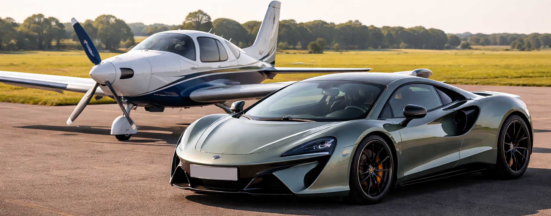 A McLaren parked next to a light aircraft
